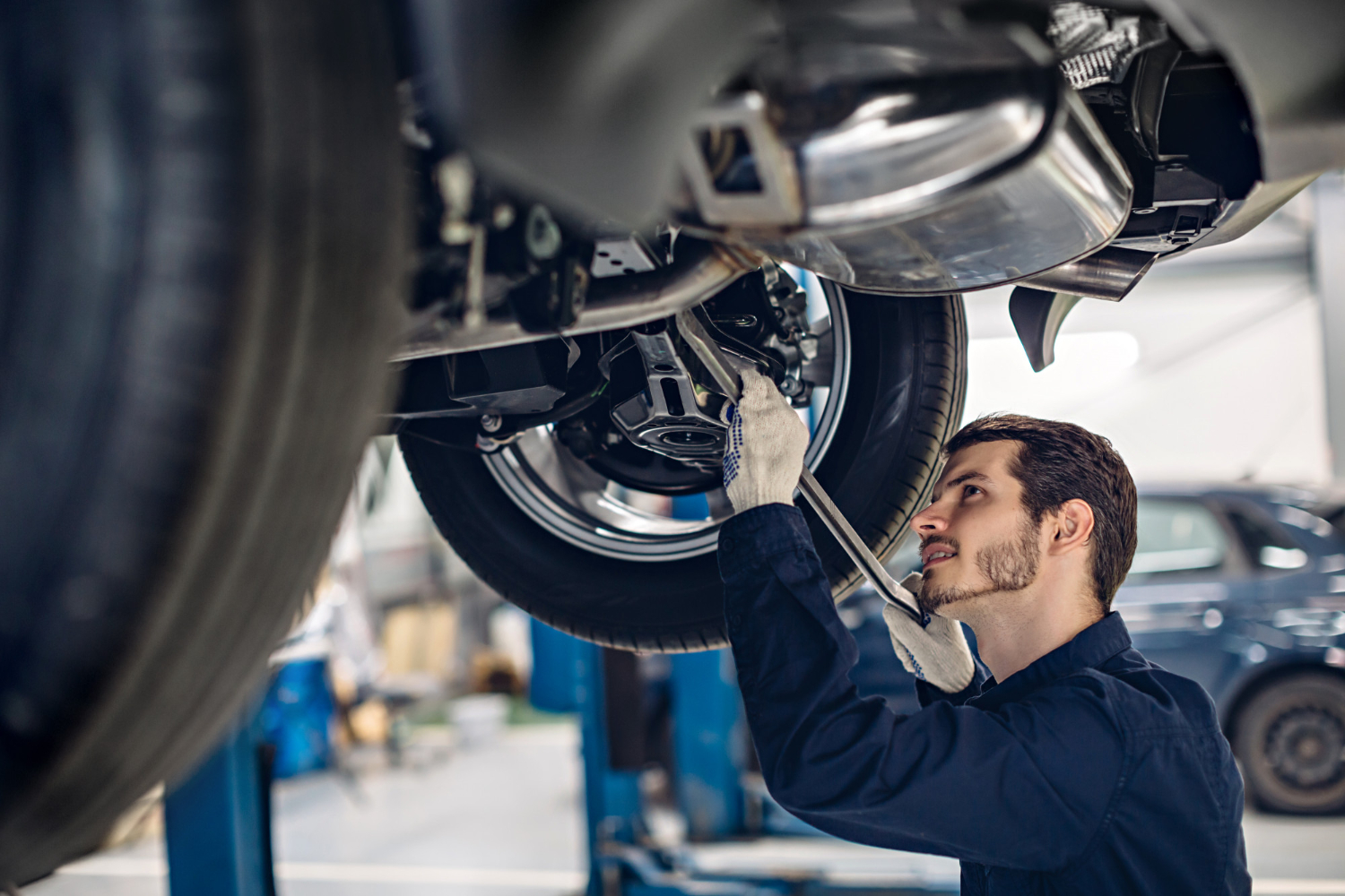 auto-car-repair-service-center-mechanic-examining-car-suspension Vehicle Maintenance