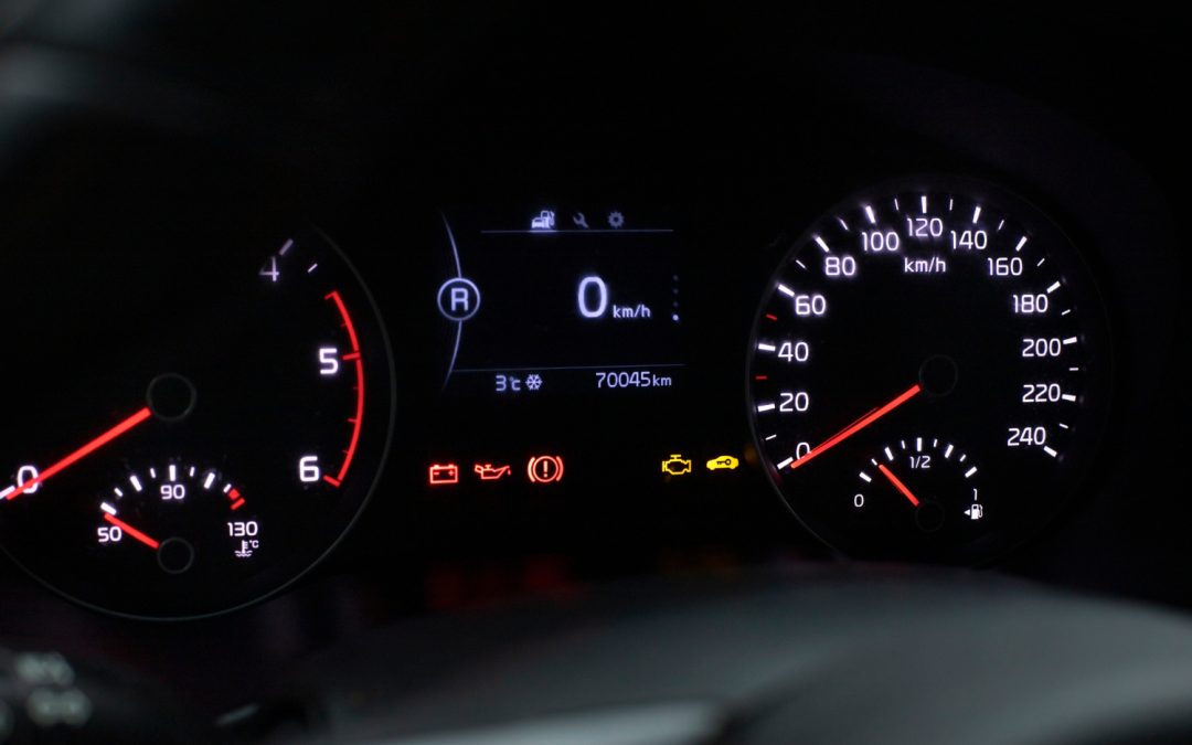 Close-up of a car dashboard showing warning lights, odometer at 70045 km, and speedometer at zero.